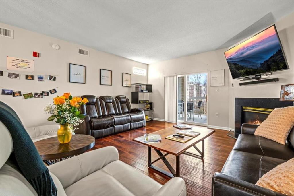 a living room with leather furniture and a fireplace at 2 King BRs Balcony Resort Amenities Free Tix in Pigeon Forge
