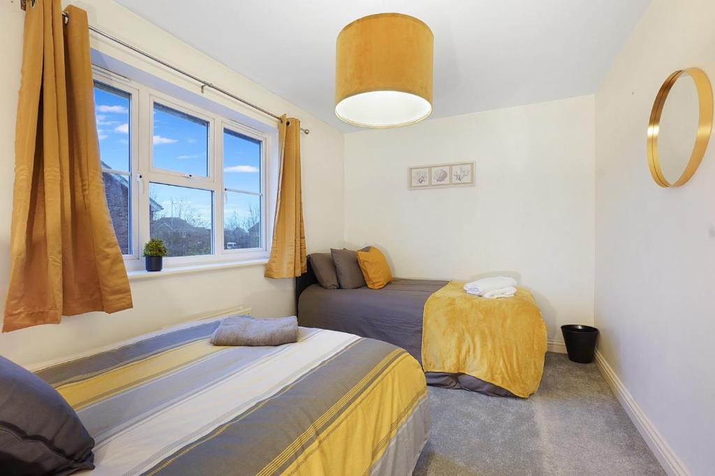 una camera da letto con due letti e una finestra di Ashford Stay Parkfarm location Comfortable with Netflix to chill ad Ashford