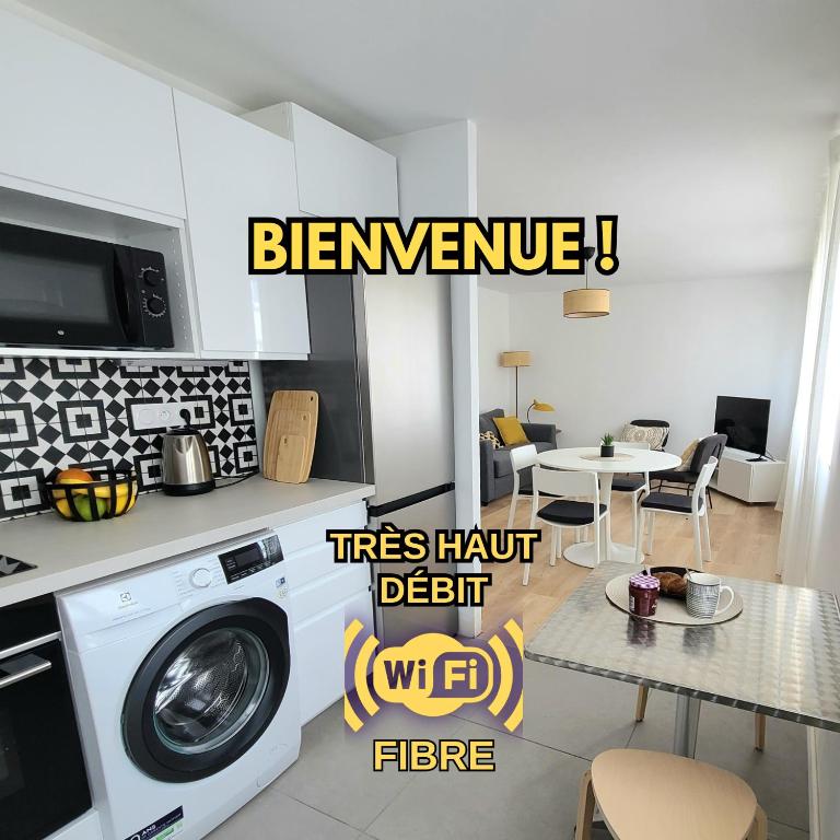 une cuisine avec un lave-linge et une salle à manger dans l'établissement Le Gouedic - 2 chambres - 3 lits - 60m2, à Saint-Brieuc