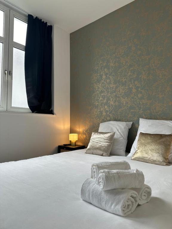 a bedroom with a bed with towels on it at Maison de l'Aar Appartement le Diamant luxueux et neuf 2 chambres Grand Salon Séjour in Strasbourg