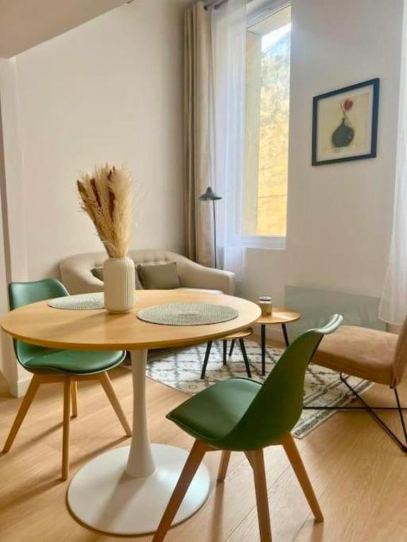 un salon avec une table et des chaises dans l'établissement Studio de charme au centre de Montpellier!, à Montpellier