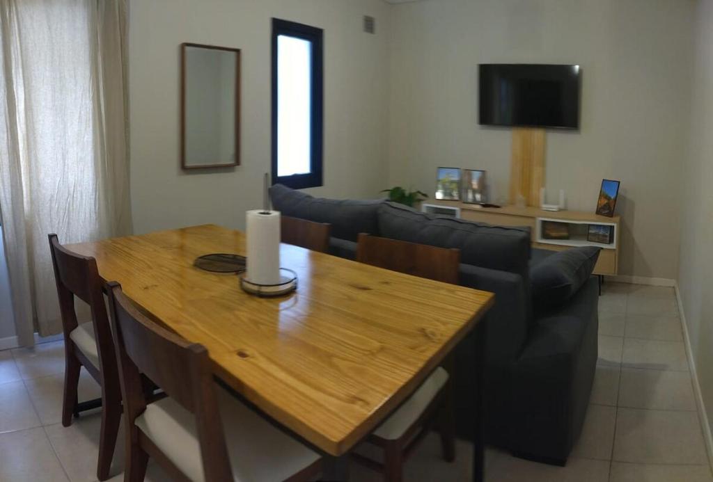 a living room with a wooden table and a couch at Departamento Maipú Ruta del vino in Maipú