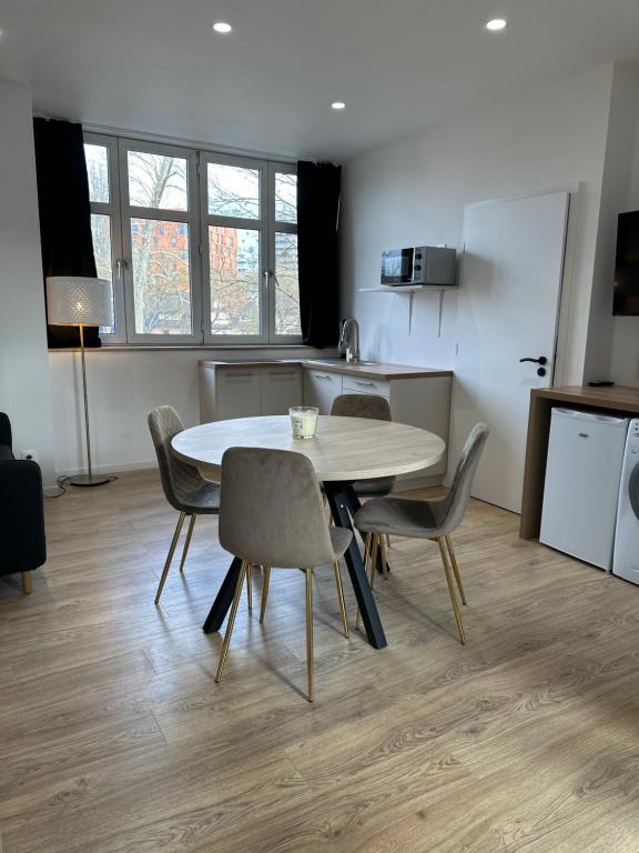 une cuisine et une salle à manger avec une table et des chaises dans l'établissement Maison de l'Aar Appartement Le Rubis luxueux et cosy neuf, à Strasbourg