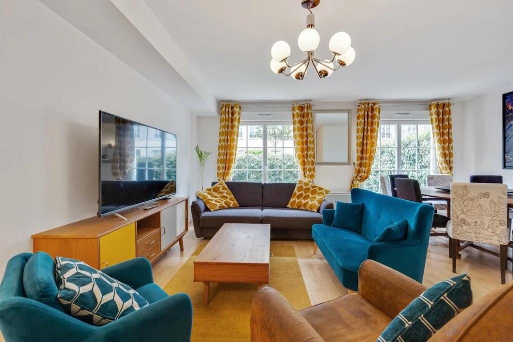 a living room with blue furniture and a tv at Accommodation closest to Disneyland in Serris