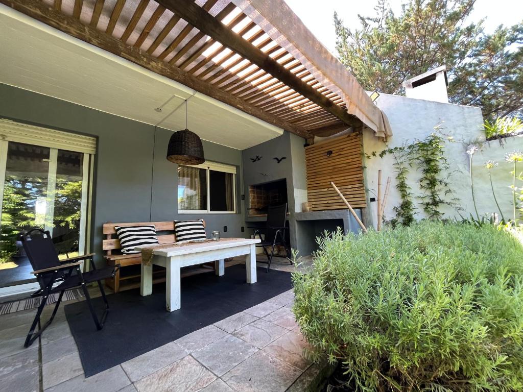 a patio with a white bench and a table at Puerta Azul in Punta del Este
