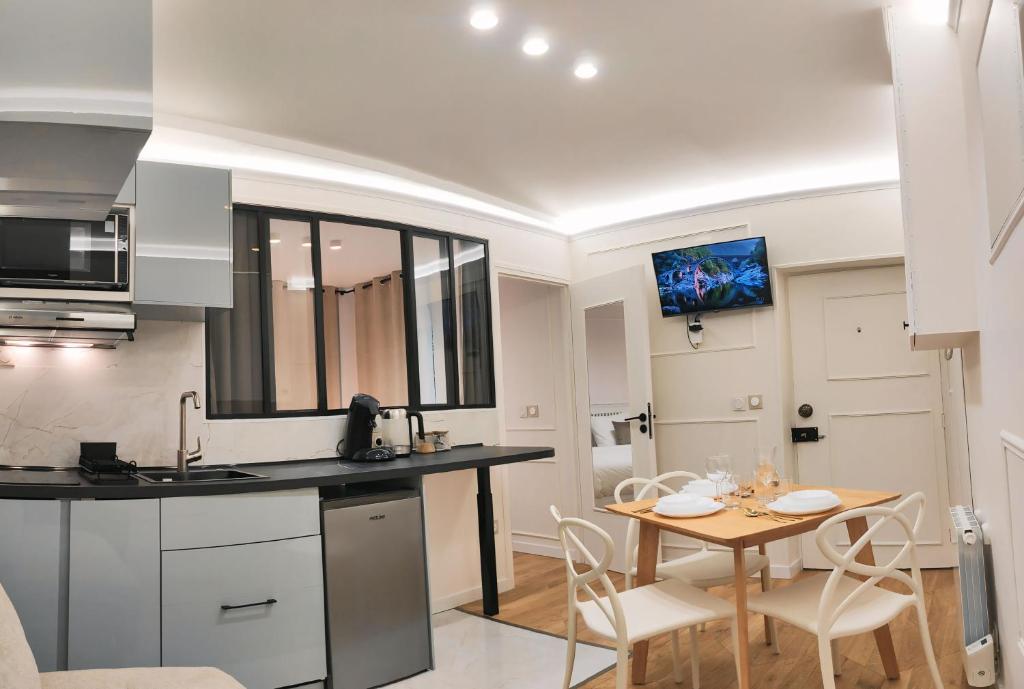 une cuisine et une salle à manger avec une table et des chaises dans l'établissement Appartement -Paris Bastille LIGHT, à Paris