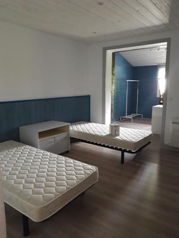 Cette chambre comprend 2 lits et un miroir. dans l'établissement Maison esperantza, à Saint-Pée-sur-Nivelle