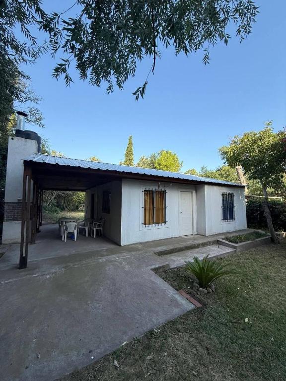 un edificio blanco con patio y mesa en Casa de Playa - 6 Personas, en Balneario Pehuén-Có