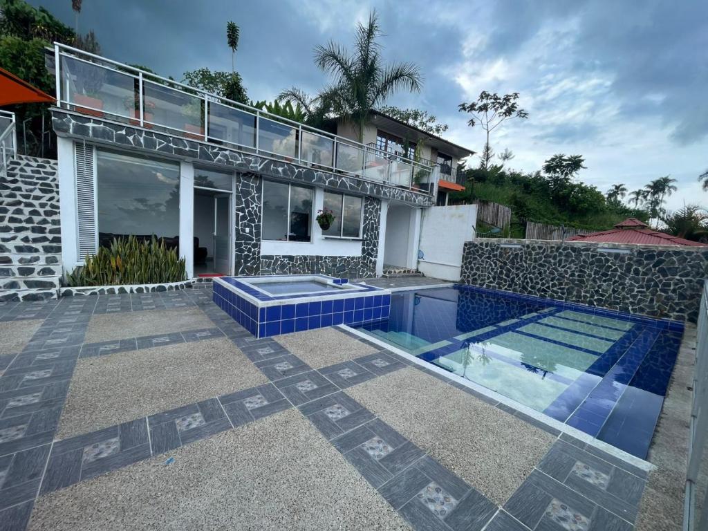 a villa with a swimming pool and a house at Villa Carolina Casa Campestre in Montenegro