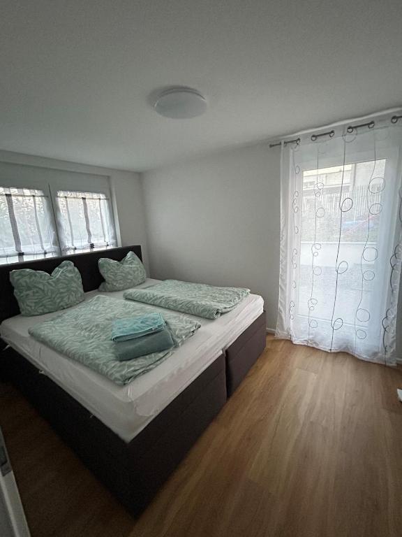 a bedroom with a bed with a wooden floor at Ferienwohnung Sonnenblick in Hilzingen