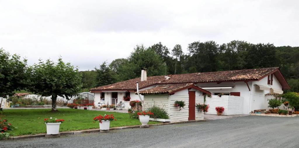 une maison blanche avec des fleurs devant elle dans l'établissement Esperantza, à Saint-Pée-sur-Nivelle