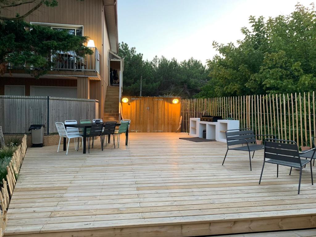 un patio avec des chaises et une table et une clôture dans l'établissement Les Hérons, à Lège-Cap-Ferret