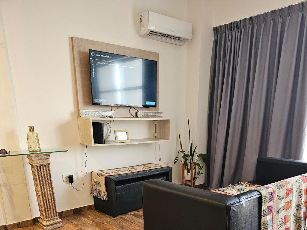 a living room with a flat screen tv on a wall at Departamento Ezeiza in Ezeiza