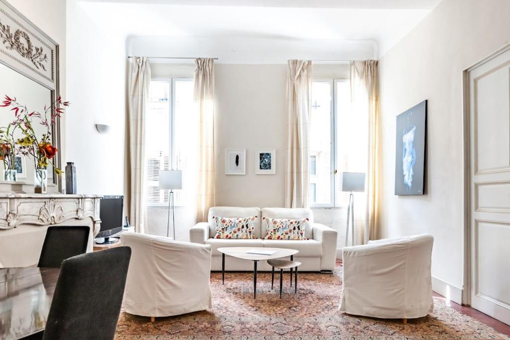 un salon avec un canapé, une table et des chaises dans l'établissement Bel appartement près du Cours Mirabeau, à Aix-en-Provence