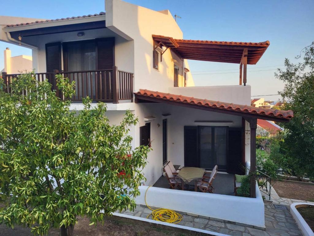 una casa con 2 sillas en un balcón en Casa De Vacacion, en Gerakini