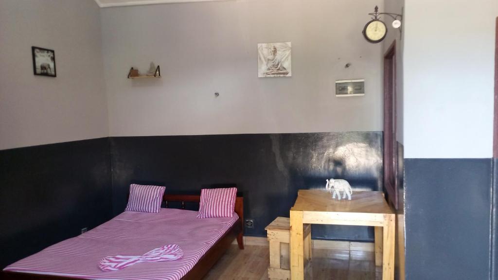 a room with two beds and a table with a purple mattress at N'goki beach in Djéno