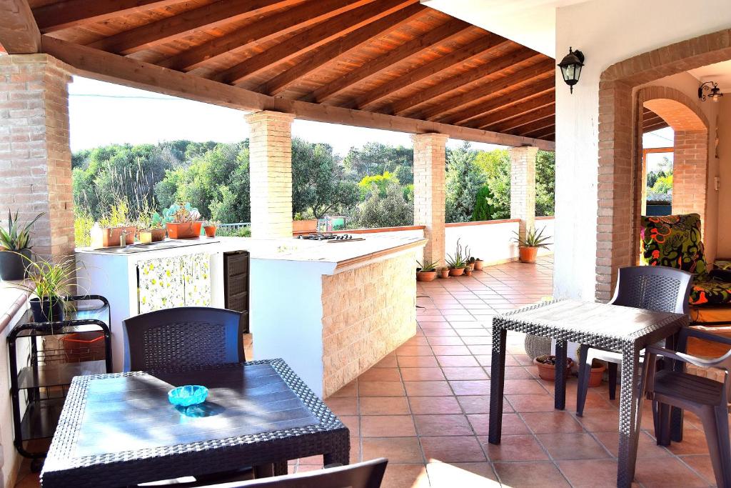 an outdoor patio with a kitchen and a table and chairs at Mi casa es tu casa 79 in Portoscuso