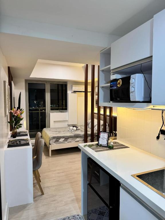 a kitchen and living room with a bed in the background at La Rynaz - Azure North in Pampang