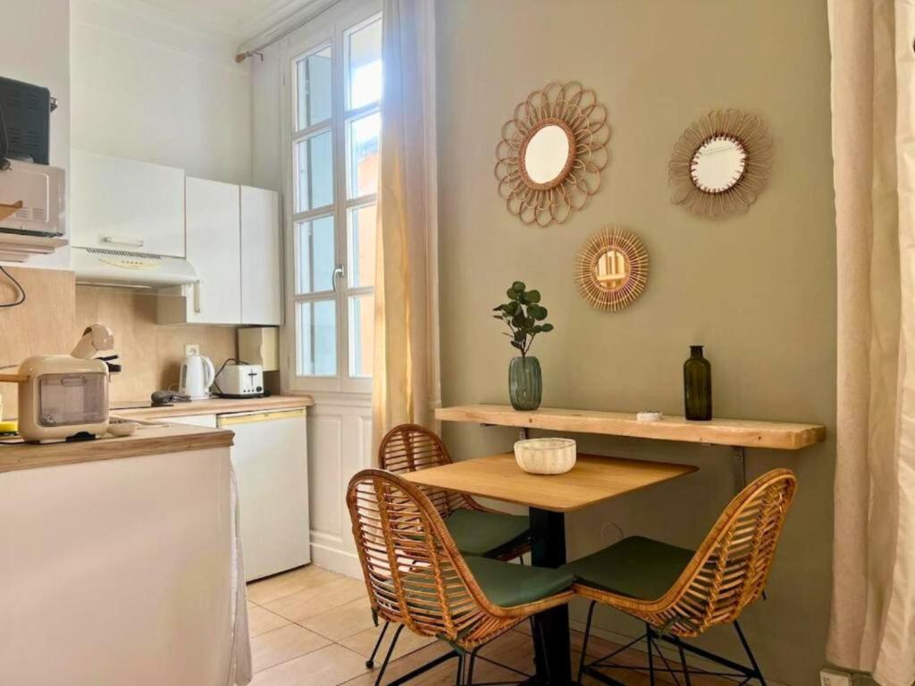 une cuisine avec une table et des chaises dans une cuisine dans l'établissement Studio bohème au coeur de Montpellier!, à Montpellier