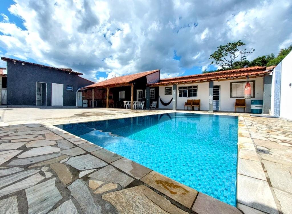 a villa with a swimming pool and a house at Estância Oliveira in Socorro