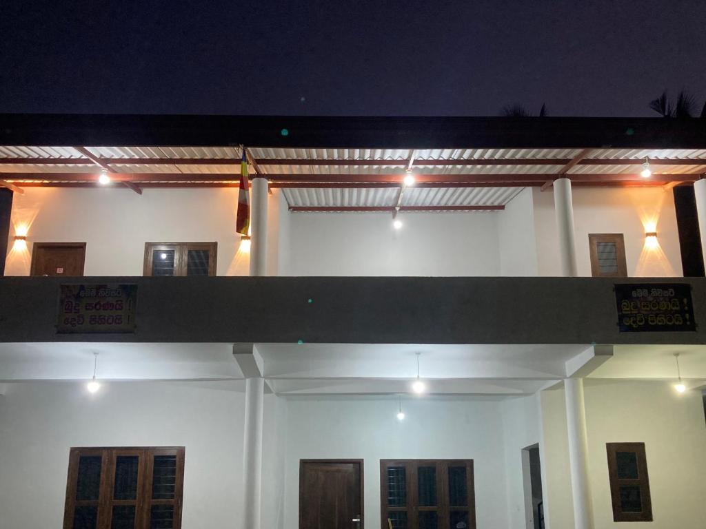 阿努拉德普勒Yu T Home Stay Anuradhapura的一座白色的大建筑,上面有灯