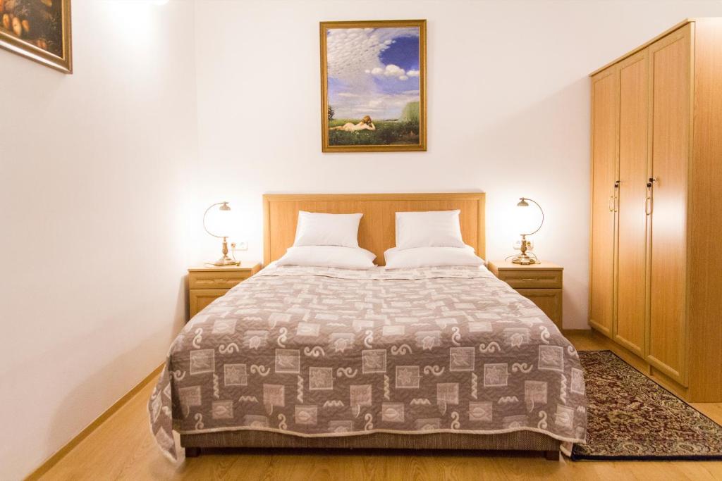 a bedroom with a large bed with two night stands at Authentic Grand Boulevard in Budapest