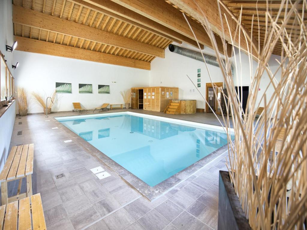 - une grande piscine dans une grande pièce dotée de plafonds en bois dans l'établissement Apartment in 3 Vallées with Pool & Sauna, à Orelle
