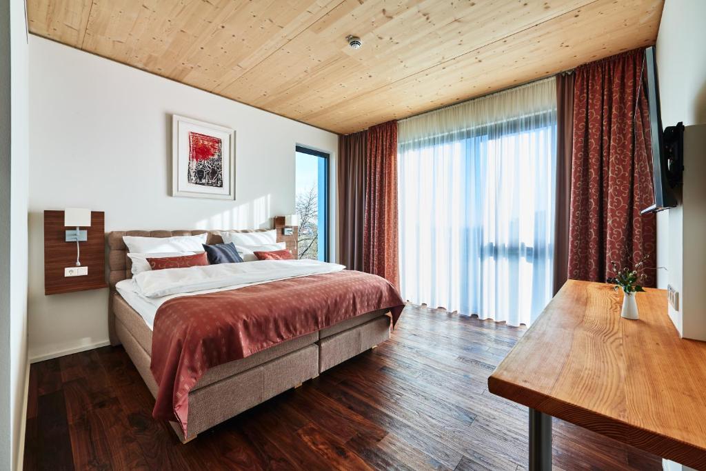 a bedroom with a large bed and a large window at Hotel 2050 in Rutesheim
