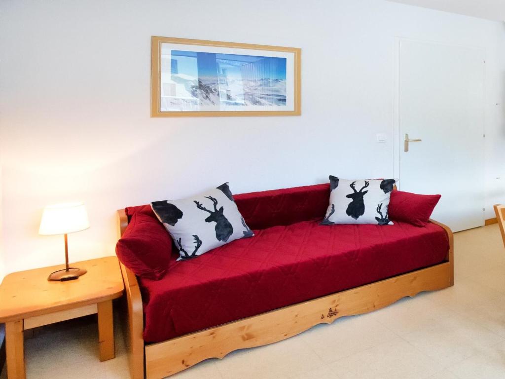 - un canapé rouge avec deux oreillers dans l'établissement Apartment Termignon near Ski Lift, à Val Cenis