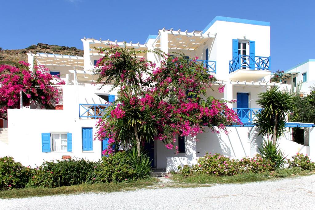 a white building with pink flowers in front of it at Argo-studios in Kini