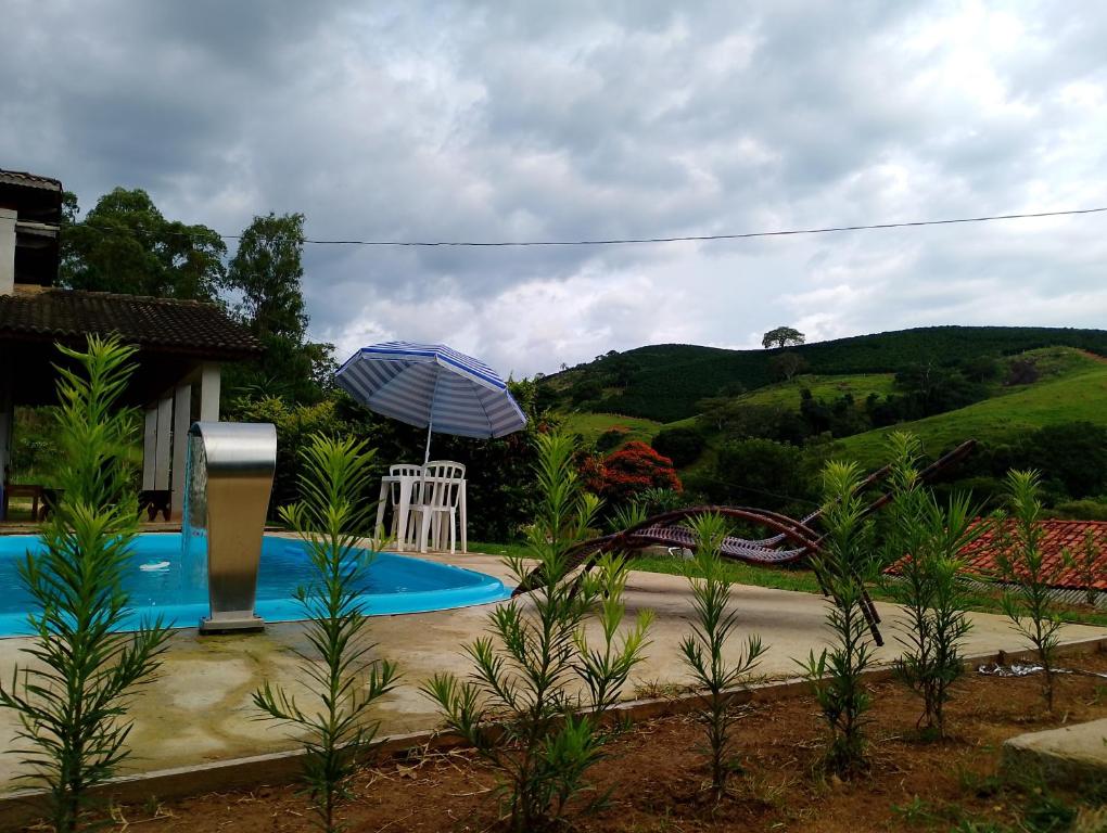 una piscina con sombrilla y montaña rusa en Chácara bela vista, en Socorro