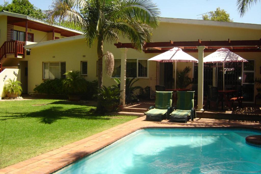 a house with a swimming pool in front of a house at Cedar Lodge Guest House in Robertson