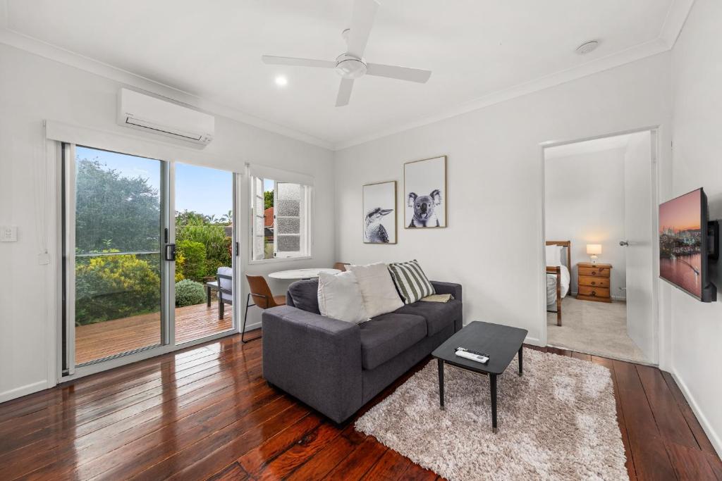 a living room with a couch and a table at Charming 1-Bed Cottage with Garden Retreat in Bald Hills