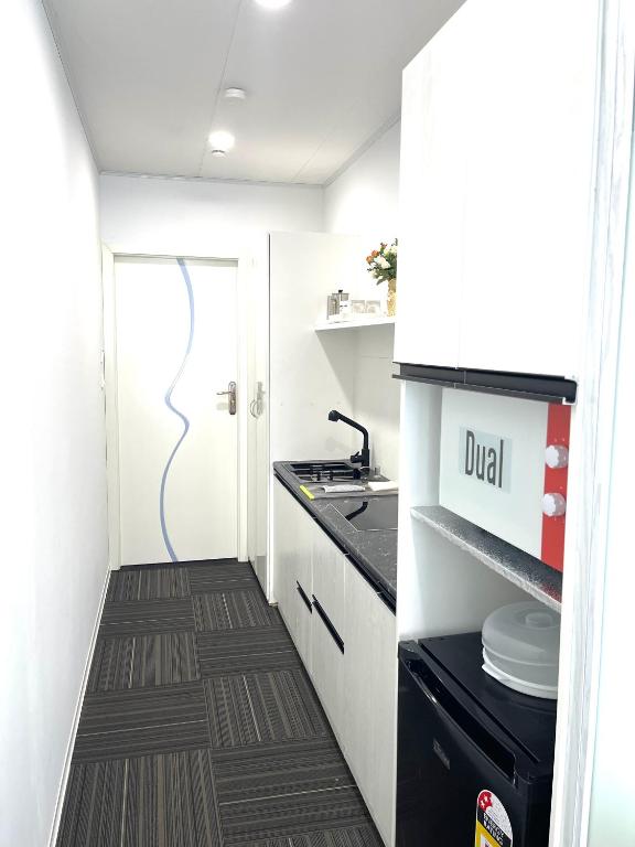 a small kitchen with a sink and a stove at Amber Lake C in Auckland