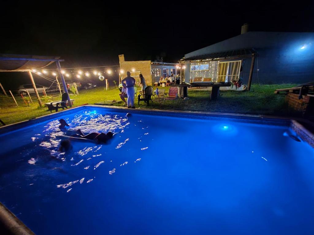 ein Pool mit blauem Wasser in einem Hof bei Nacht in der Unterkunft El Retoño in Esquina
