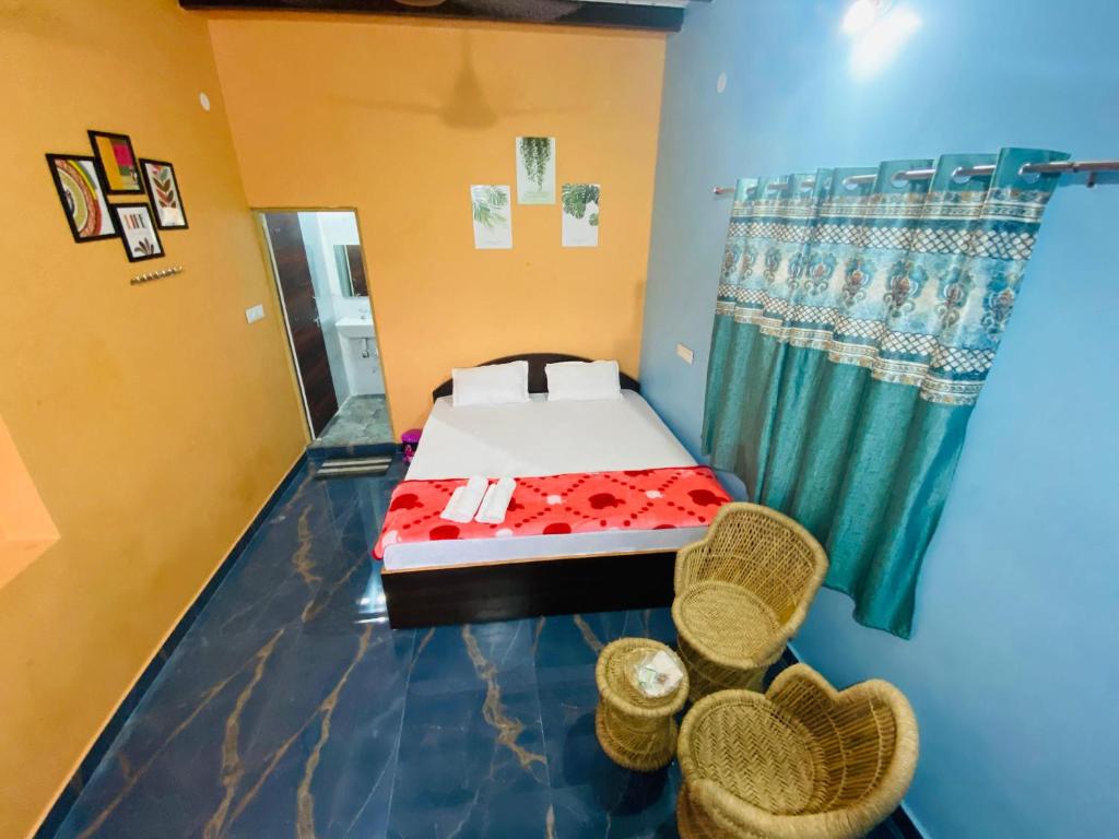 Cette petite chambre comprend un lit et deux chaises. dans l'établissement Varaha Homestay Hampi, à Hampi