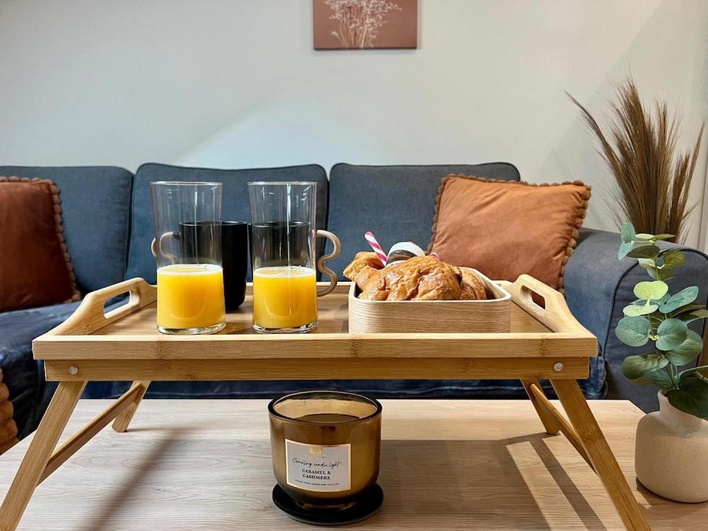 - une table basse avec un plateau de nourriture et du jus d'orange dans l'établissement Appartement Cosy avec Netflix et parking gratuit, à Montataire