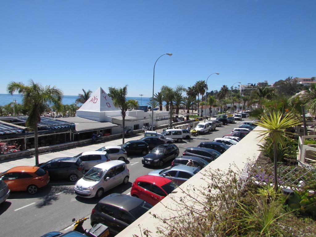 a parking lot with a lot of cars parked at Home4Holidays in Nerja