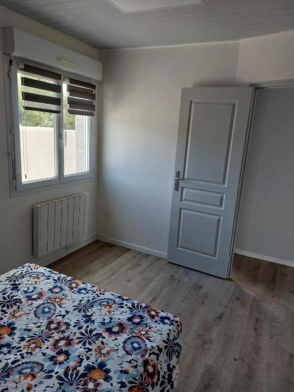 - une chambre vide avec un lit et une porte dans l'établissement La détente, à Saint-Georges-de-Pointindoux