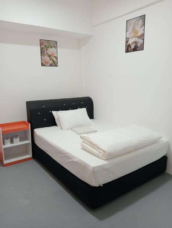 a bedroom with a bed with a black headboard at H Budget Hotel in Johor Bahru