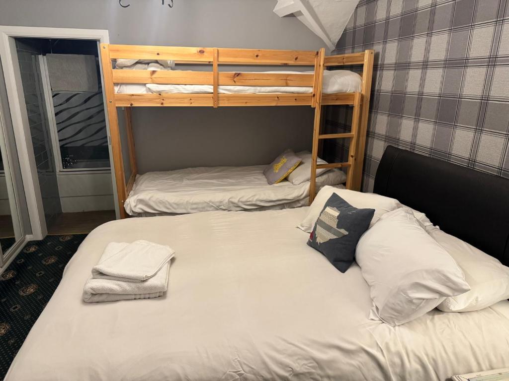 two bunk beds in a small room with a bed at Holland Hotel in Llanfachraeth