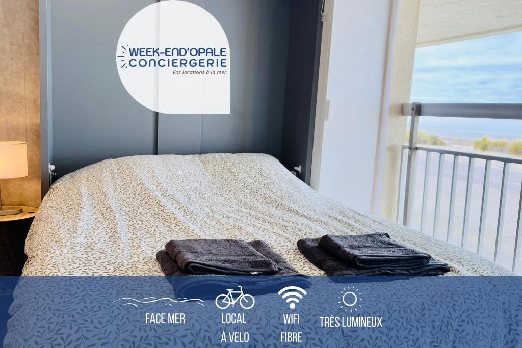 une chambre avec un lit avec deux serviettes dessus dans l'établissement L'horizon bleu - Vue mer - Berck-sur-mer, à Berck-sur-Mer