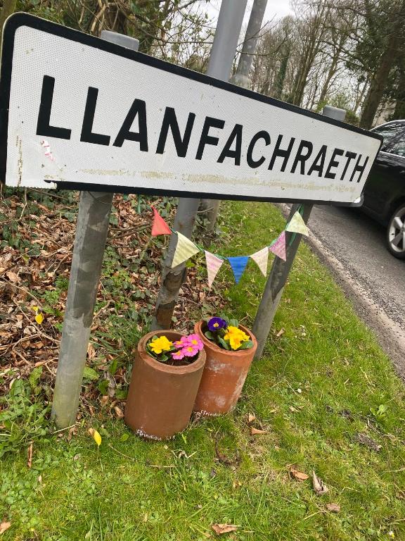 a street sign with two flower pots on the side of a road at Holland Hotel in Llanfachraeth