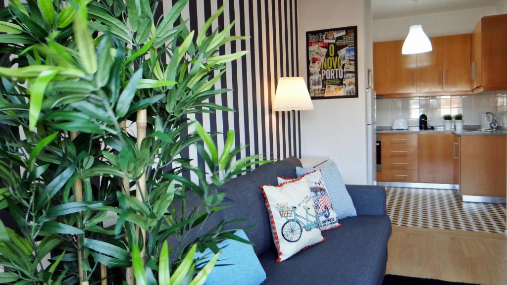 uma sala de estar com um sofá azul e uma planta em Design Apartment Porto Downtown no Porto