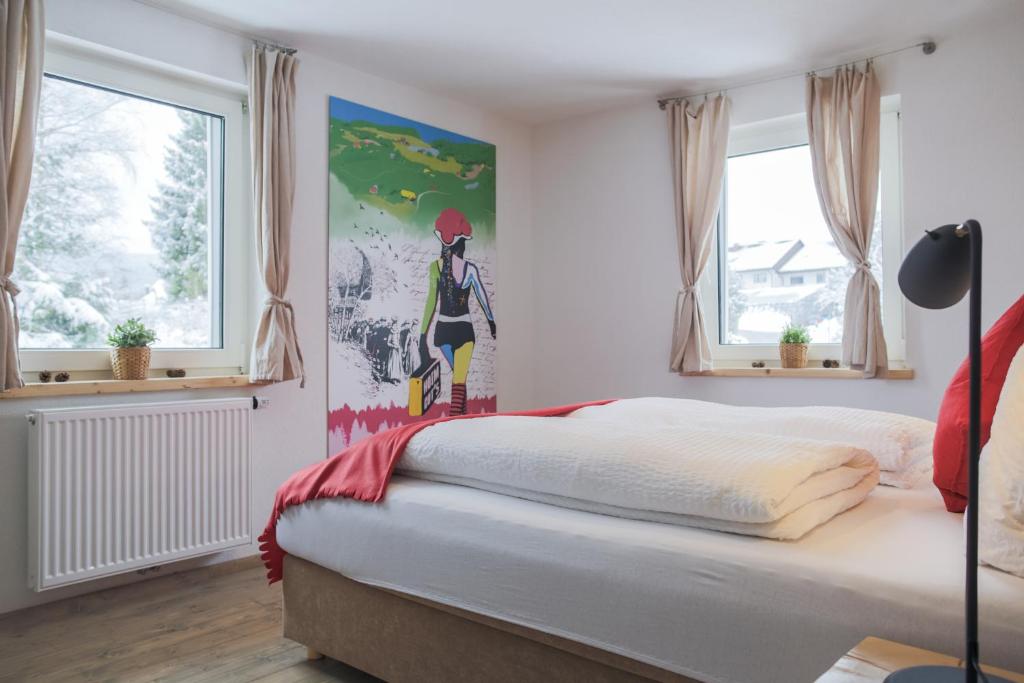 ティティゼー・ノイシュタットにあるKuckucksnest Neustadtのベッドルーム1室(ベッド1台付)が備わります。壁には絵画が飾られています。