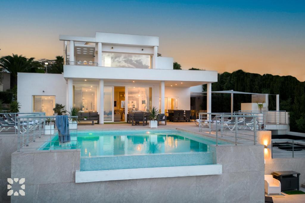 a house with a swimming pool in front of it at Villa Punta Vista by Abahana Villas in Cumbre del Sol