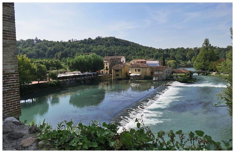 明喬河畔瓦萊焦的住宿－Corte La Guarnigione，一条河,河的两边有房子