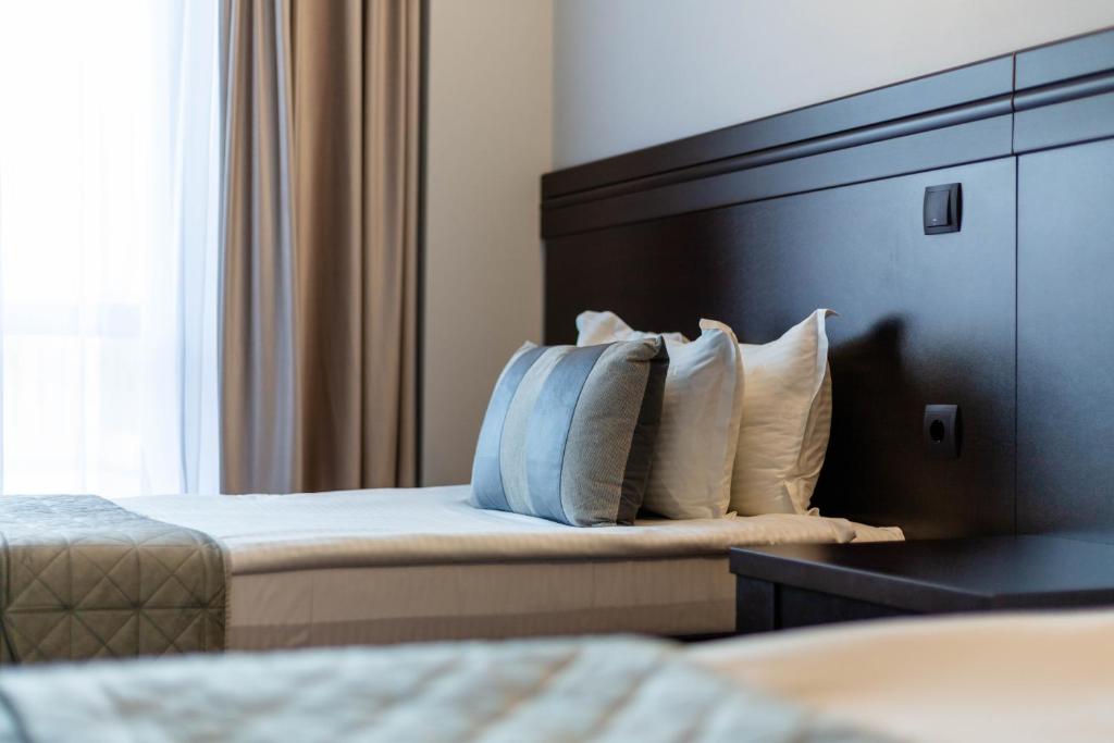 a hotel room with two beds and a headboard and pillows at Hotel Restaurant Alesia in Corunca