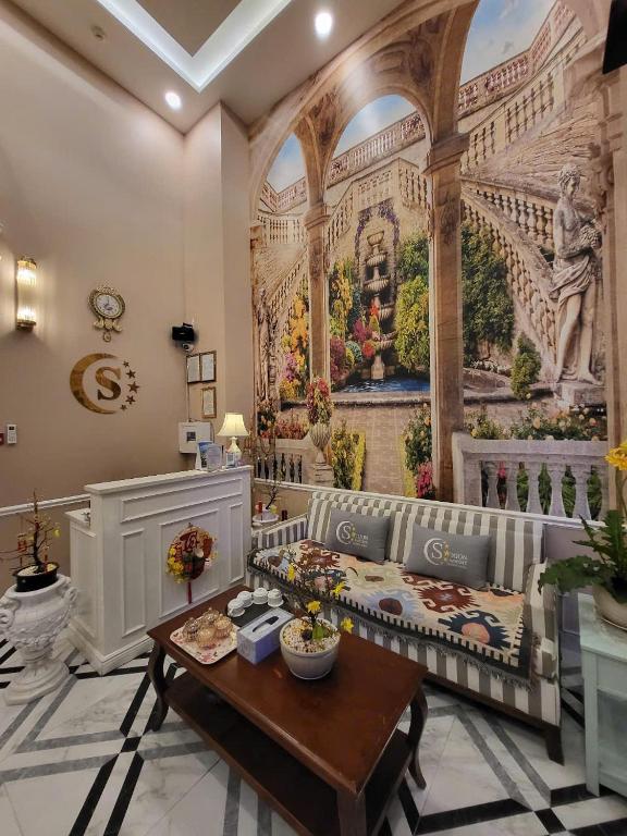 a living room with a large painting on the wall at Saigon By Night Luxury Hotel in Ho Chi Minh City