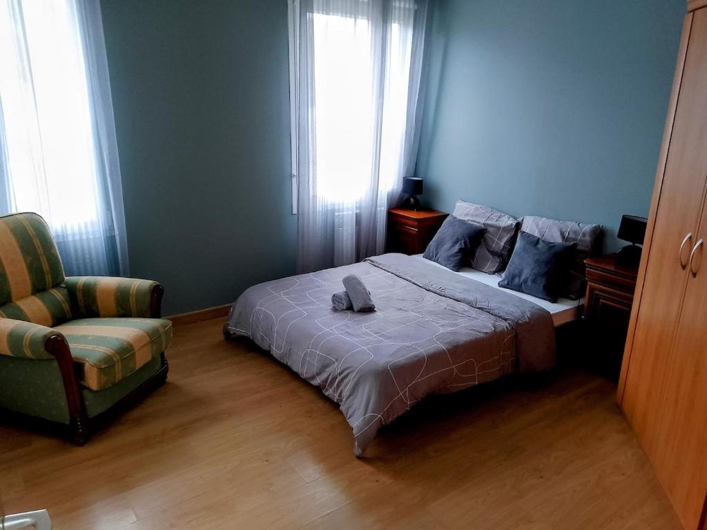 a bedroom with a bed and a chair and a window at Le Coin Cozy in Carhaix-Plouguer